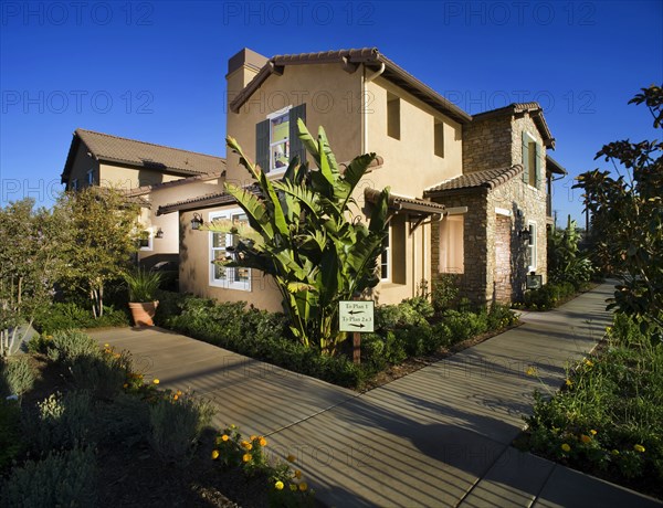 Sidewalk and landscaping along contemporary tuscan style home