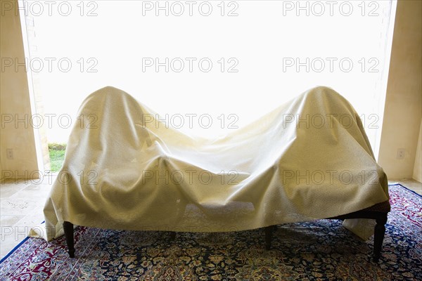 Two chairs covered in a white sheet