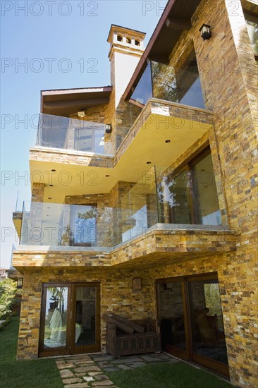 Rear exterior of a large tuscan style home with balconies