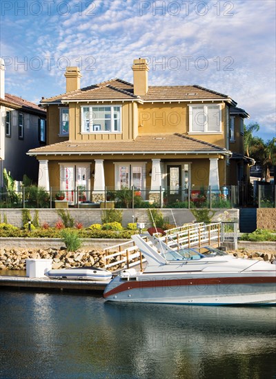 Exterior of one story house with speedboat in lake