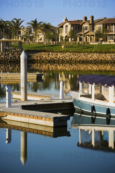 Boats docked at housing community near channel to ocean