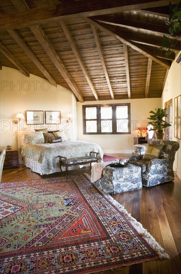 Large master bedroom with vaulted ceilings and area rug