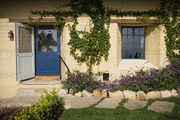 Front exterior of a spanish style home with a blue door