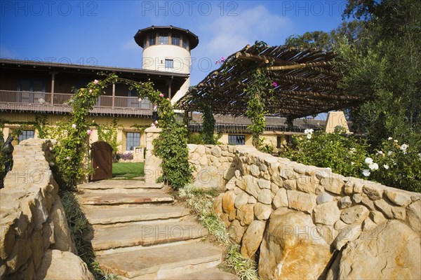 Stone steps leading up to a large spanish style home