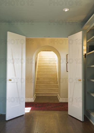 Open double doors leading to an upward staircase