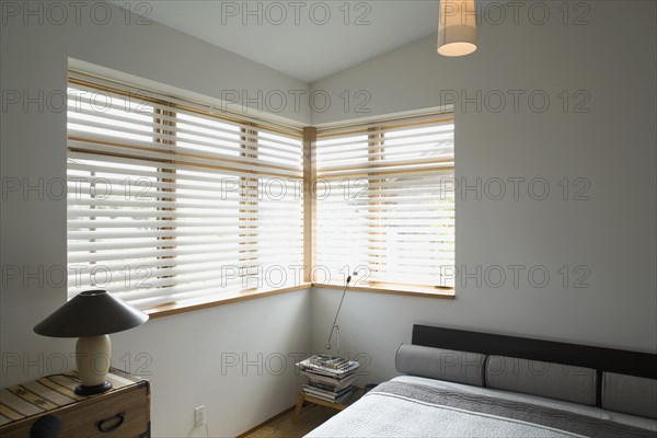 Contemporary bedroom with gray bed and corner windows