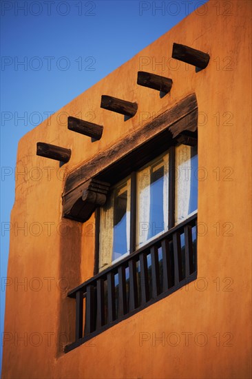 Low angle view of posts and window in adobe house