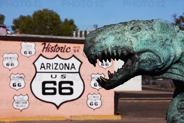 Close up of dinosaur statue by Historic Route 66 sign
