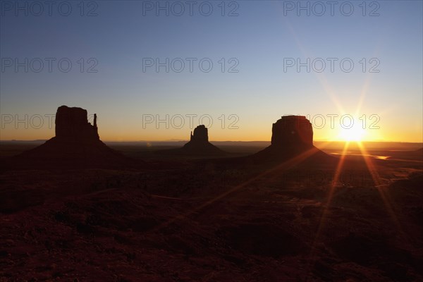 Butte rock formations in desert landscape at sunset