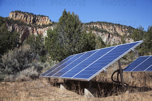Solar panels in remote field near mountains