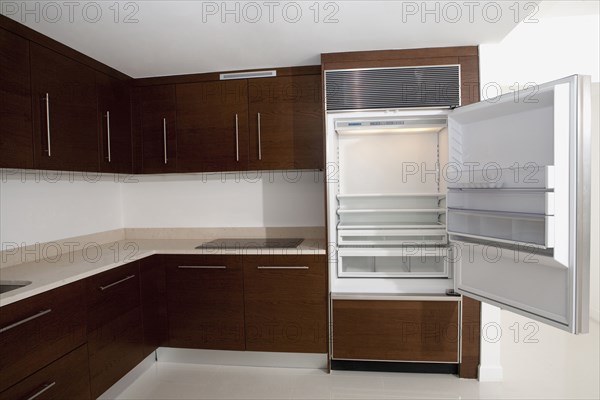 Open refrigerator in empty kitchen