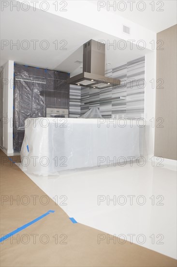 Protective plastic and paper tarps in kitchen under renovation