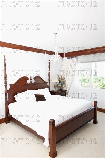 Four-poster bed and window in ornate bedroom