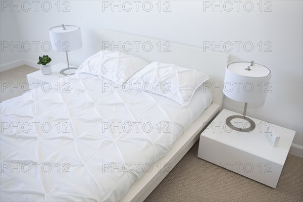 High angle view of bed and night tables in modern bedroom