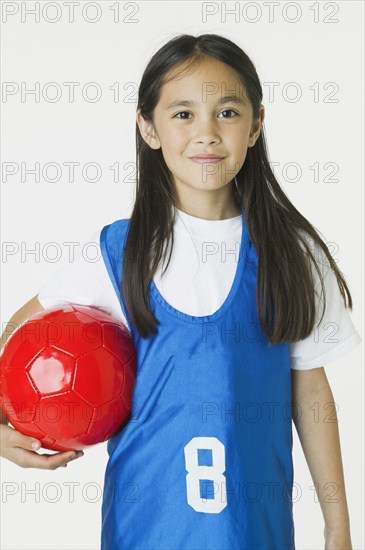 Asian girl holding soccer ball