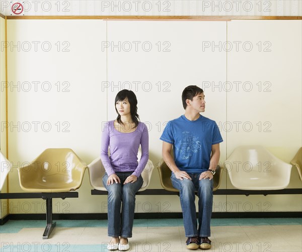 Asian couple sitting in waiting area