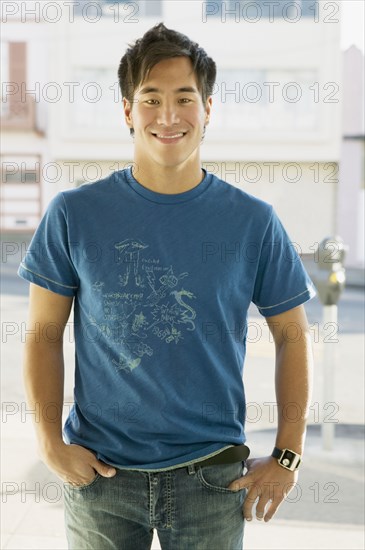 Asian man with hands in pockets