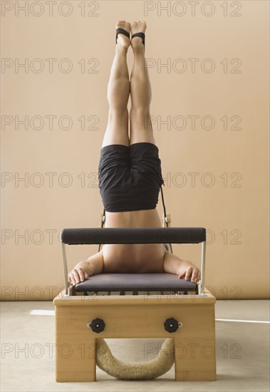 Asian man stretching on exercise equipment