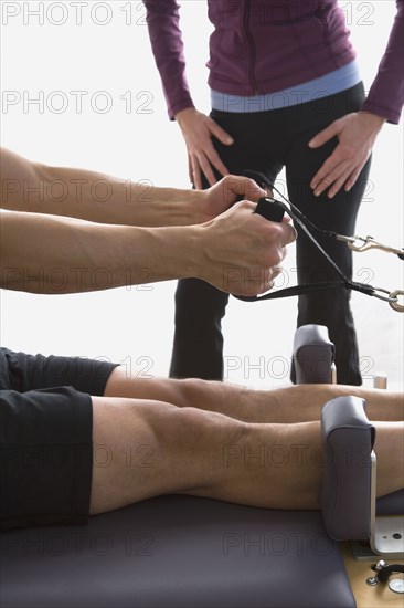 Asian man stretching on exercise equipment