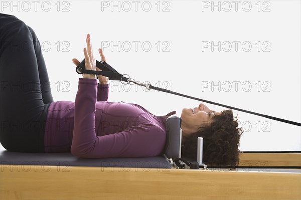 Senior woman stretching on exercise equipment