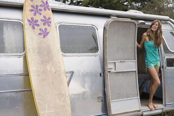 Mixed race woman standing in doorway of camper