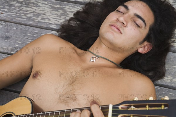 Pacific Islander man holding ukulele