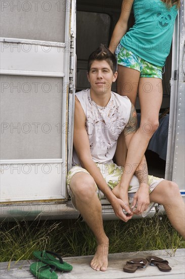 Multi-ethnic couple in doorway of camper