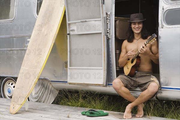 Pacific Islander man playing ukulele