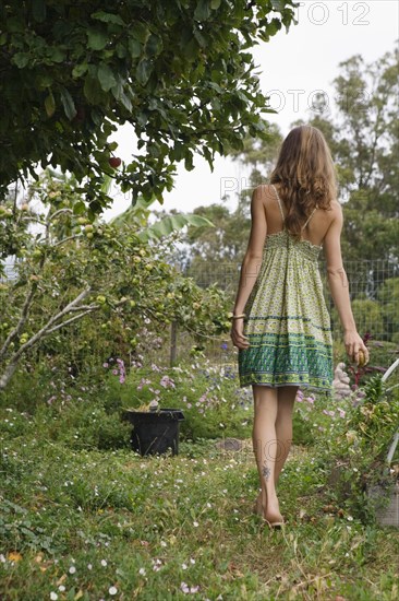 Mixed race woman talking next to fruit trees