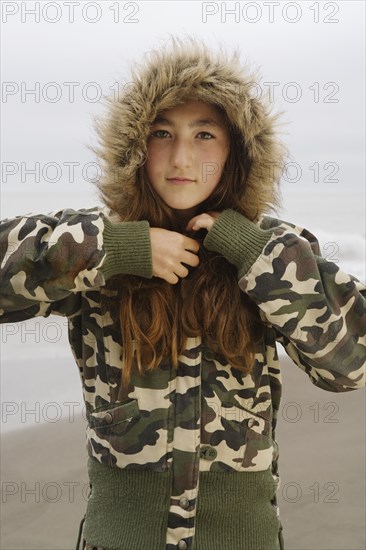 Mixed Race girl wearing jacket at beach