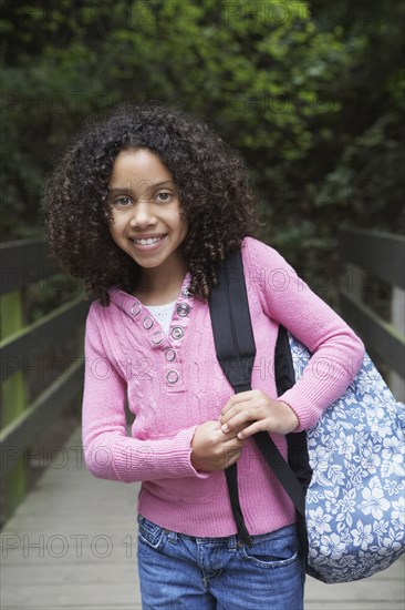 Mixed race girl walking with backpack