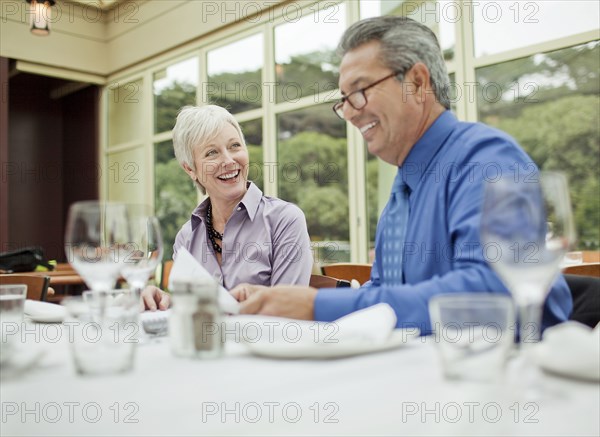 Smiling business people working at table in restaurant