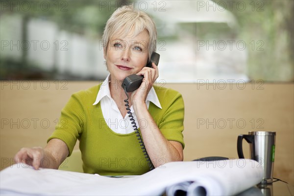 Smiling Caucasian architect talking on telephone