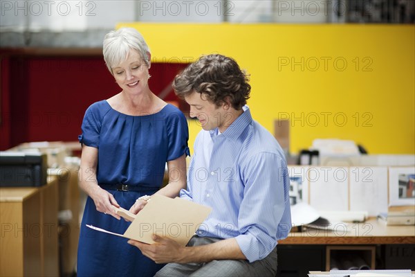 Business people reading file folder in office