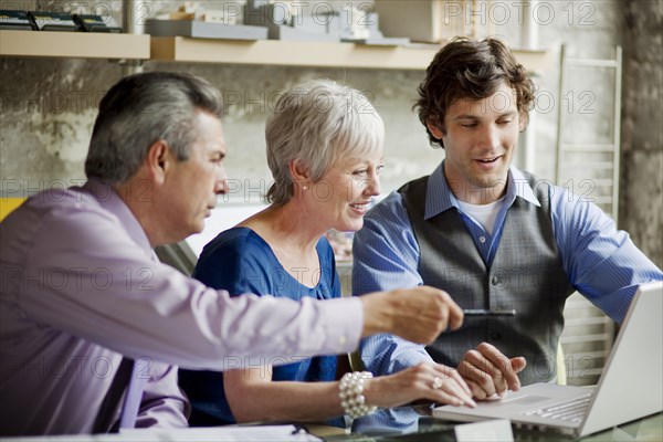 Smiling businesspeople using laptop in office