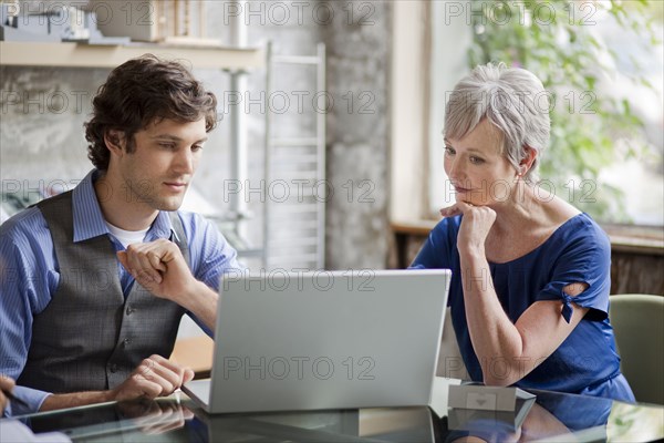 Pensive businesspeople using laptop in office