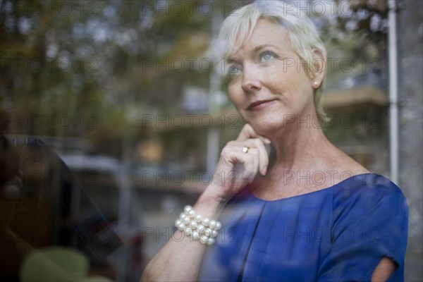 Pensive Caucasian businesswoman looking out window
