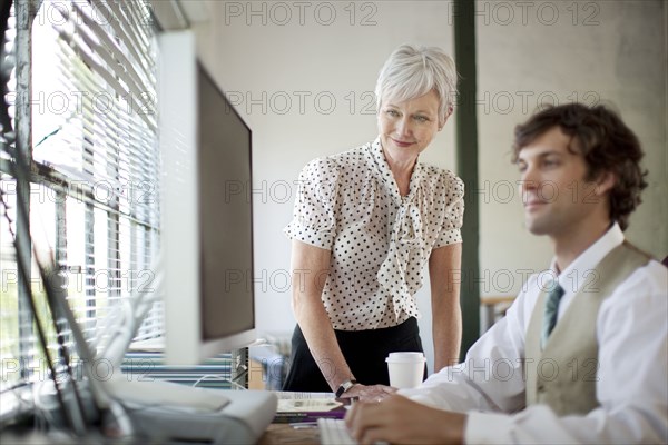 Business people using computer in office