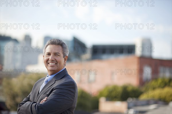 Portrait of smiling Hispanic businessman posing outdoors