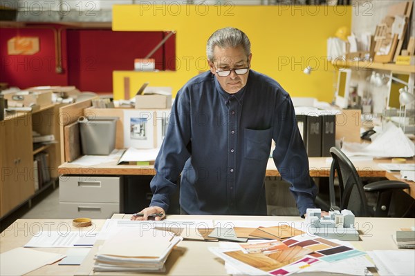 Serious Hispanic designer examining color swatches in office