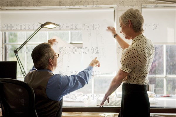 Architects examining blueprint in office