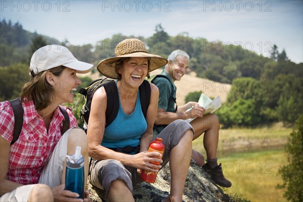 Hikers siting on rock and laughing