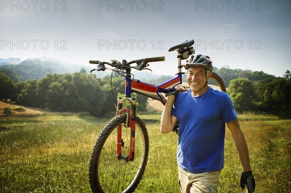 Caucasian man carrying mountain bike