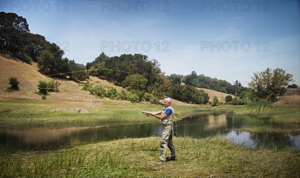 Caucasian man fishing at river