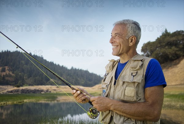 Caucasian man fishing at river