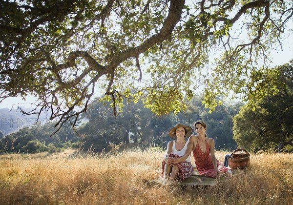 Portrait of smiling women relaxing on picnic blanket