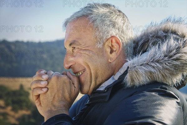 Smiling Caucasian man wearing coat with fur hood