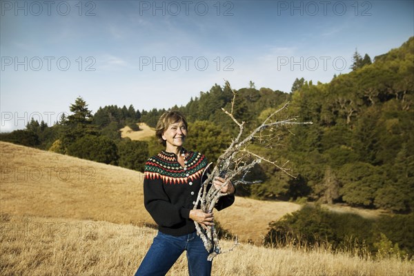 Smiling Caucasian woman gathering branches