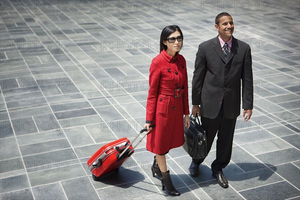 Business people with briefcase and rolling suitcase