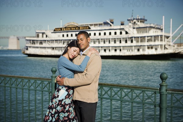 Couple hugging at waterfront near boat